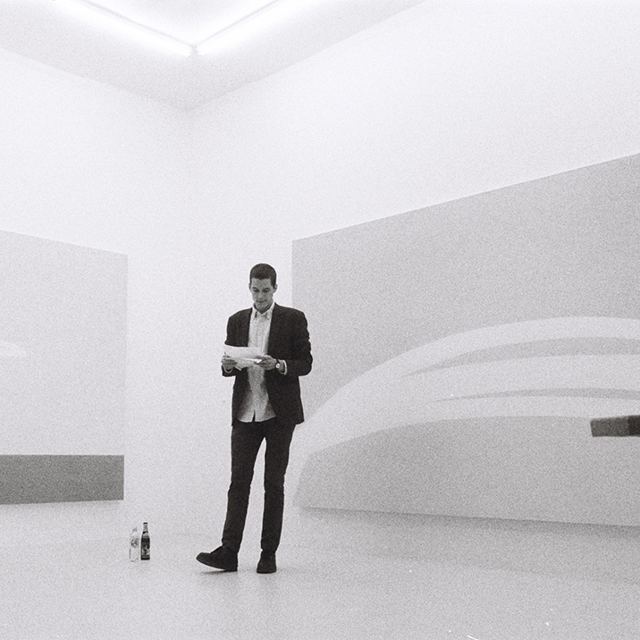 Image of Keith J Varadi standing in front of an artwork by Priscilla Tea.